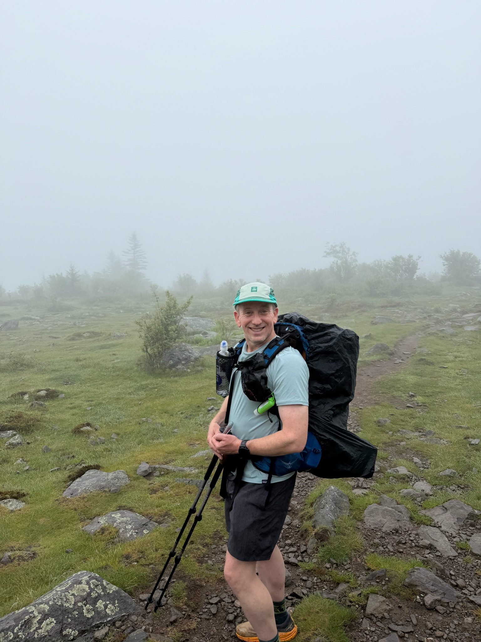 Alex smiling with his backpack on a foggy Appalachian Trail ridge